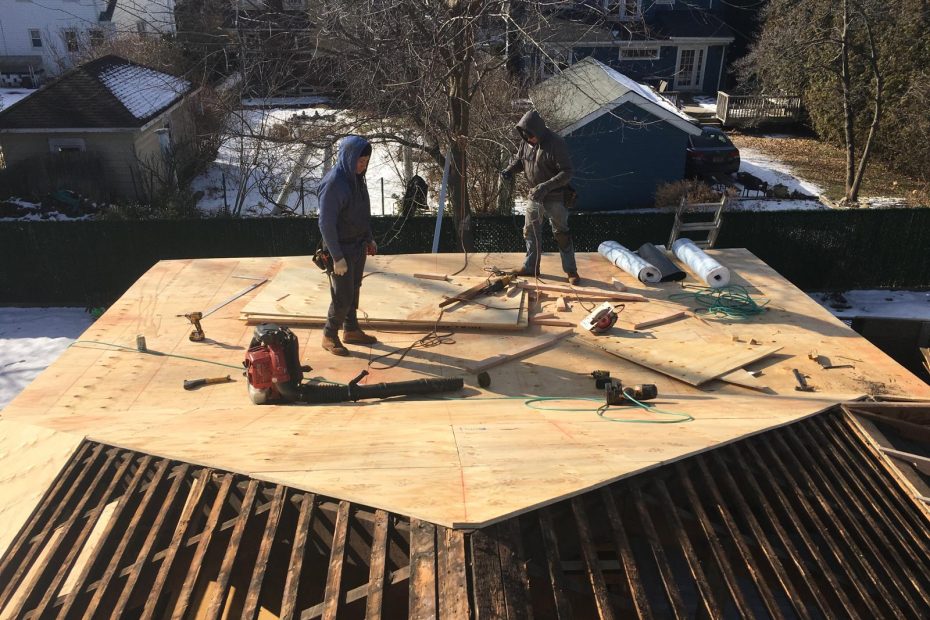 Roofing contractor fixing siding and gutters while helping homeowners with insurance claims